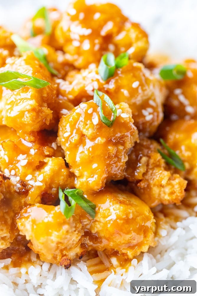 Crispy Zesty Vegan Orange Chicken 6 Close-up detailed shot of a single piece of vegan orange chicken, highlighting the intricate crispy texture and the rich, glossy orange glaze, inviting a delicious bite.