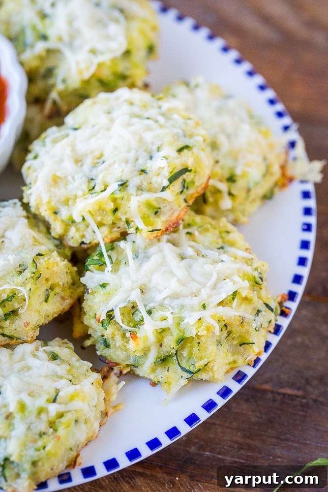Zucchini Pizza Poppers 6 Close up photo of a single Zucchini Pizza Bite on a plate with blurred background