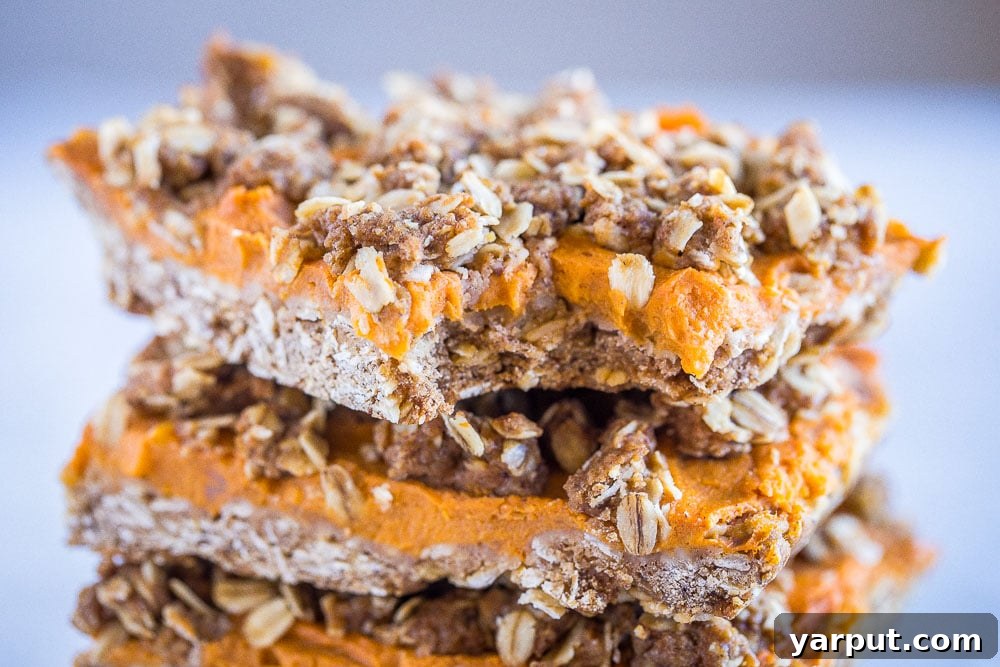 Close-up of a sweet potato pie bar with a bite taken out, showing the layers.