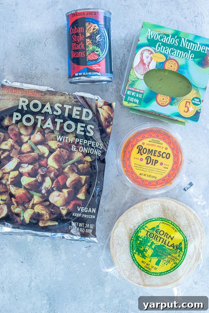 Trader Joe's Five Series: Spicy Potato Tacos with Black Beans 3 A selection of Trader Joe's ingredients laid out on a kitchen counter, showcasing the five key items needed for this quick spicy potato taco recipe, including roasted potatoes, black beans, romesco dip, guacamole, and corn tortillas.