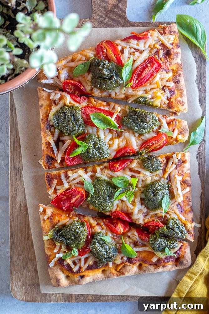 Trader Joe's Simple 5-Ingredient Vegan Tomato Pesto Pizza 7 Vegan pizza sliced on a wooden cutting board, ready to be served