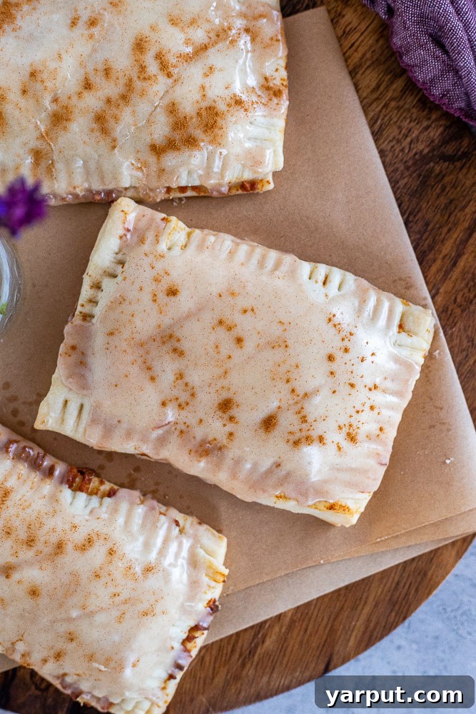 Naturally Sweetened Cinnamon Toaster Delights 6 A vibrant display of freshly baked vegan pop tarts arranged on a wooden cutting board.