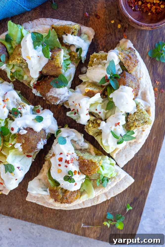 Loaded Vegan Falafel Pitas 6 Slices of an open-faced vegan falafel pita neatly arranged on a wooden cutting board, ready for serving