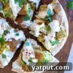 An open-faced vegan falafel pita, showing the layers of ingredients.