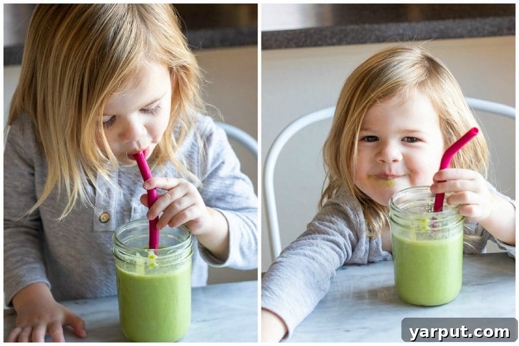 Delicious and Nutritious Green Smoothie for Kids 6 a child drinking a kid friendly green smoothie, happily enjoying their healthy beverage