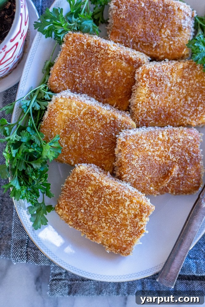 Golden Crispy Tofu Steaks 2 A beautiful platter showcasing crispy fried tofu steaks garnished with fresh parsley, ready to be served as a centerpiece for a vegan holiday meal.