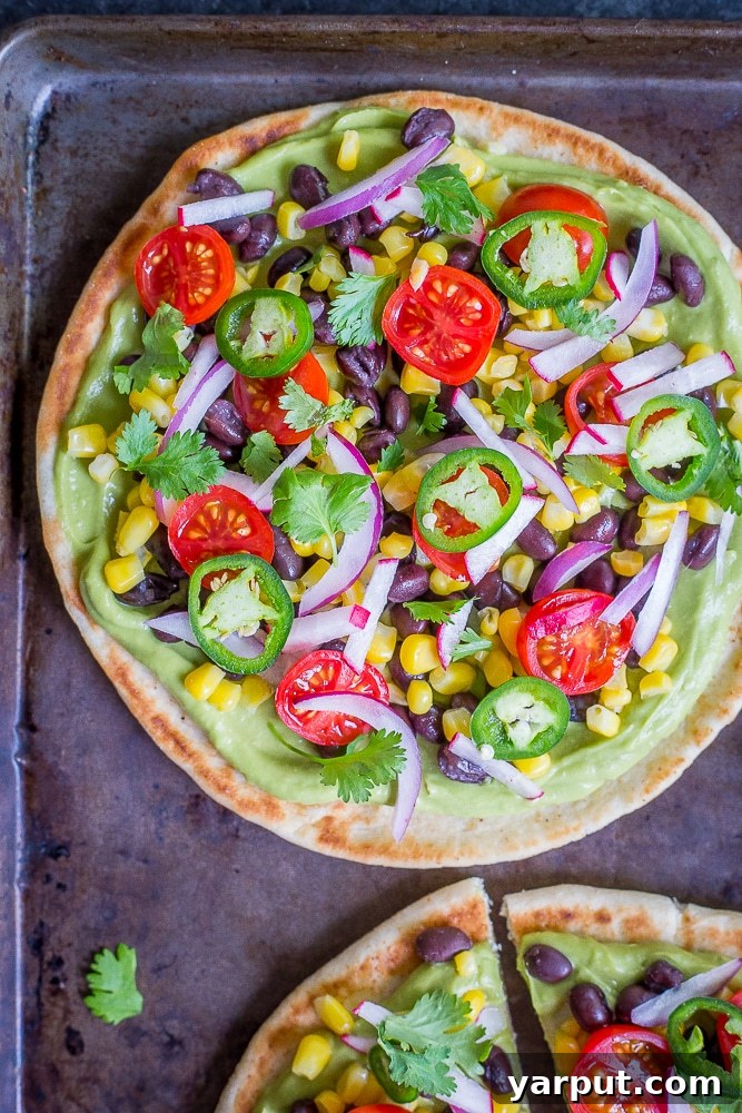 Guacamole Pita Pizzas, a fun and easy appetizer or light meal with fresh guacamole and vibrant toppings.