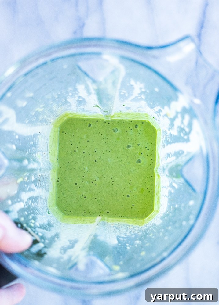 Vibrant Green Tahini Dressing 4 Smooth, creamy green tahini sauce swirled inside a high-speed blender, showcasing its perfect texture