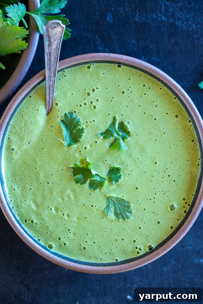 Vibrant Green Tahini Dressing 5 A large, inviting bowl of creamy green tahini sauce, perfectly blended, with a spoon nestled inside