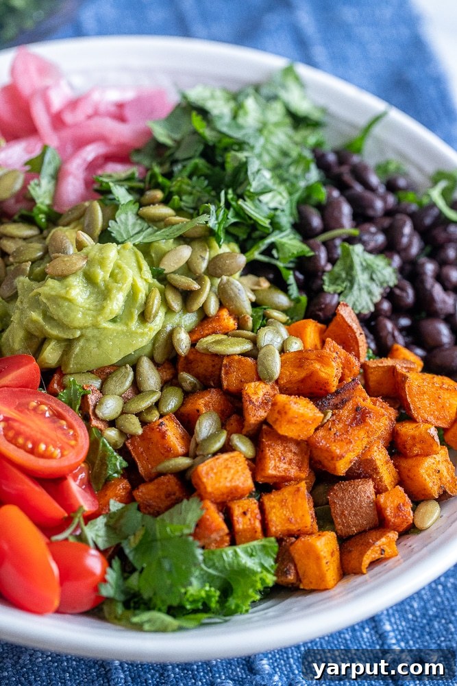 Vibrant Roasted Sweet Potato and Black Bean Kale Power Bowl 6 A close-up view of roasted sweet potato pieces mixed with fresh kale and black beans, showcasing the delicious textures and vibrant colors of the salad.