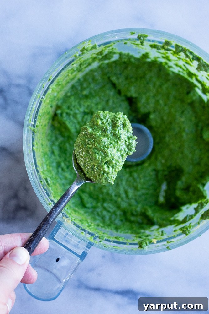Effortless Vegan Pesto 5 close up of a spoonful of vegan pesto sauce from the food processor