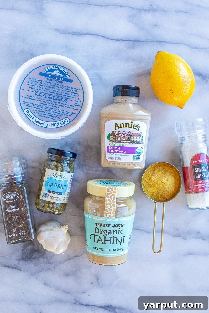 Velvety Vegan Tahini Caesar Dressing 4 all ingredients needed to make vegan Caesar salad dressing laid out on a table