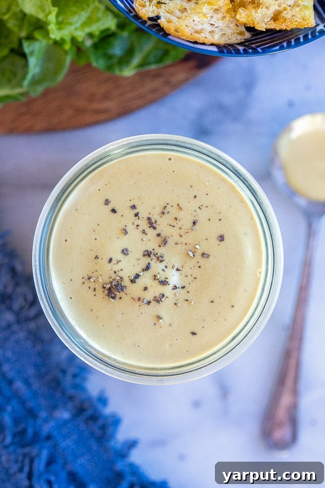 Velvety Vegan Tahini Caesar Dressing 5 close up of creamy vegan caesar dressing with tahini in a glass jar