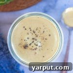 A jar of creamy vegan tahini Caesar dressing.