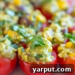 Guacamole stuffed tomatoes, a healthy and vibrant summer appetizer on a plate