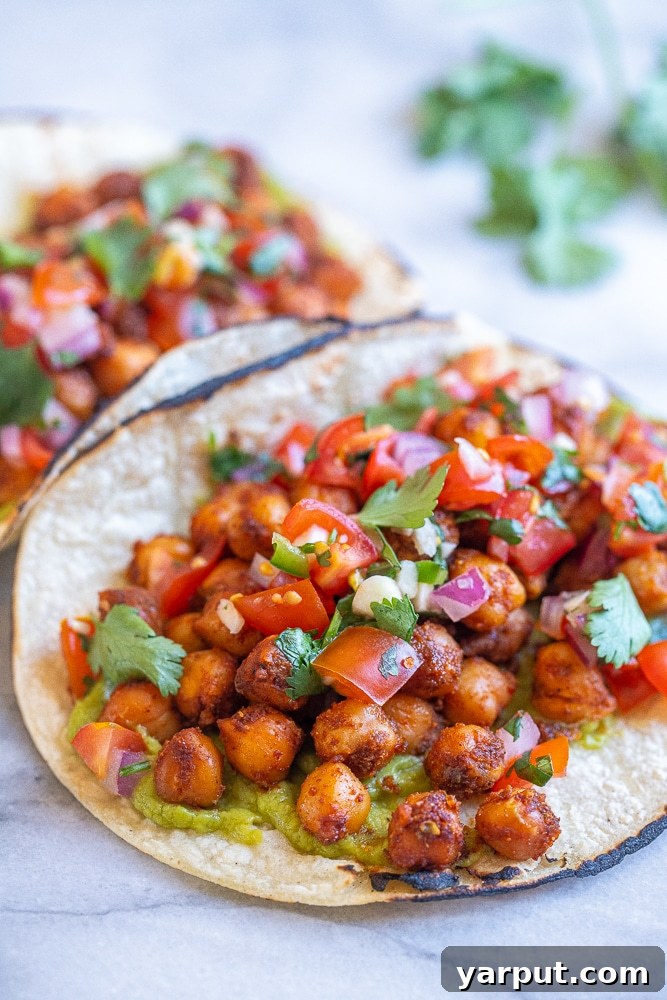 Flavorful 15 Minute Chickpea Tacos 4 Close up of easy chickpea tacos with a generous serving of guacamole and vibrant pico de gallo