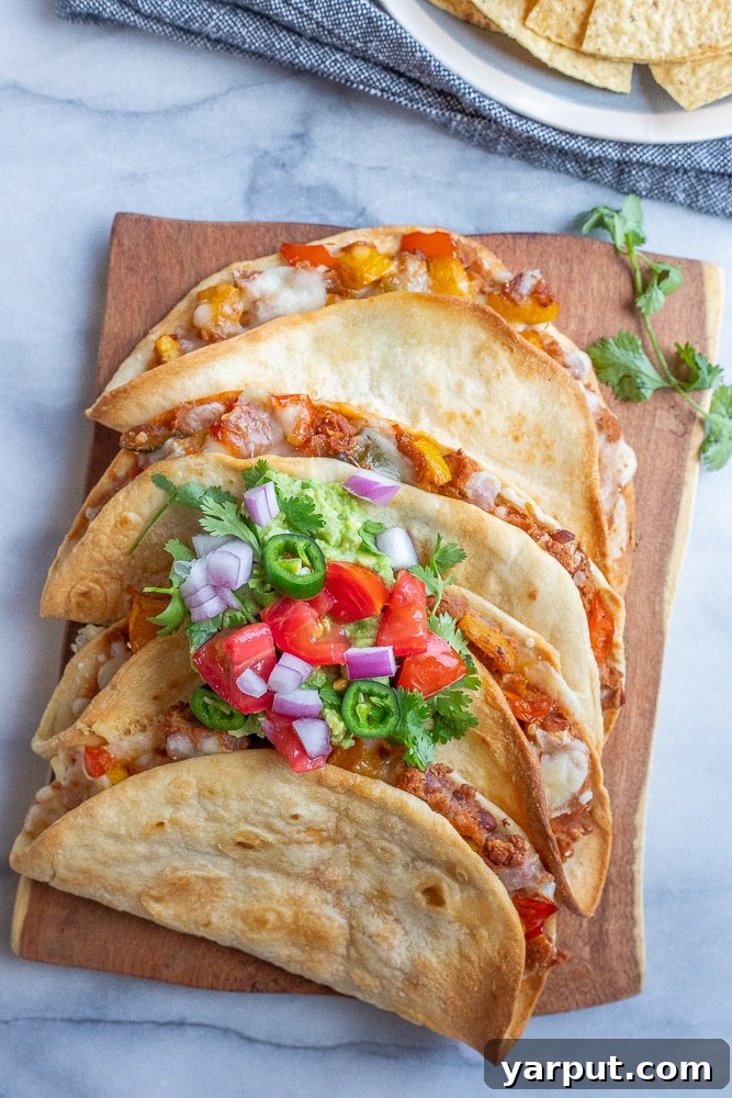 Delicious Oven-Baked Vegetarian Tacos 2 Baked Vegetarian Tacos on a cutting board with fresh toppings like avocado, salsa, and cilantro, showcasing vibrant summer vegetables