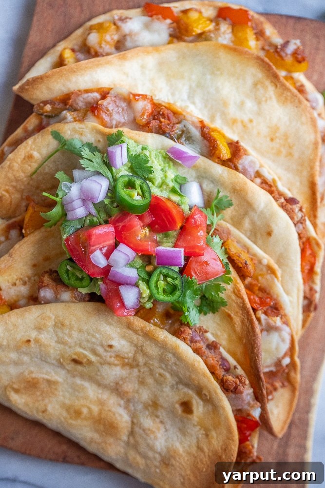 Delicious Oven-Baked Vegetarian Tacos 5 Close-up of golden-brown baked vegetarian tacos stacked on a cutting board, garnished with fresh cilantro, showcasing their crispy texture