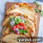 Crispy baked vegetarian taco on a wooden cutting board with fresh garnishes.