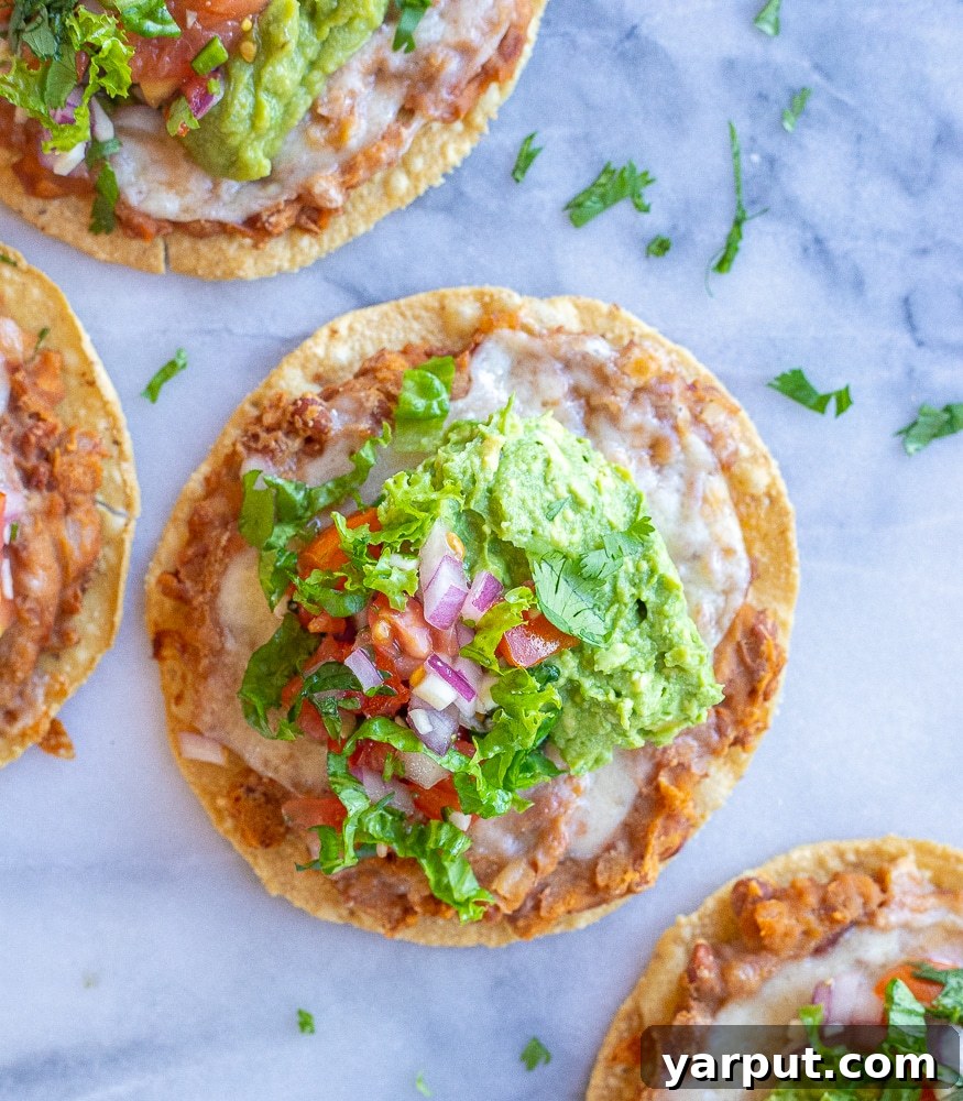 Crispy Bean and Cheese Tostadas 4 Bean and cheese tostadas on a marble cutting board, ready to be served