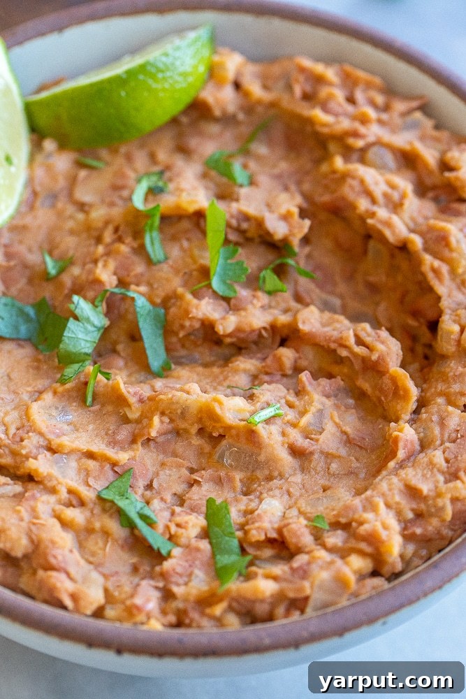 A close-up view of creamy refried beans in a bowl, showing their delightful texture and readiness for enjoyment