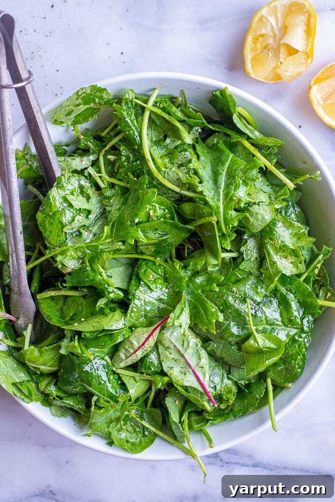 Scrumptious 5-Minute Dinner Salad 6 A bowl of fresh spring mix salad adorned with vibrant yellow lemons, highlighting the freshness and zesty flavors.