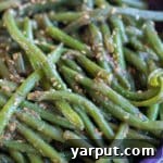 A small bowl of Miso Sesame Green Beans with a focus on the texture and sesame seeds.