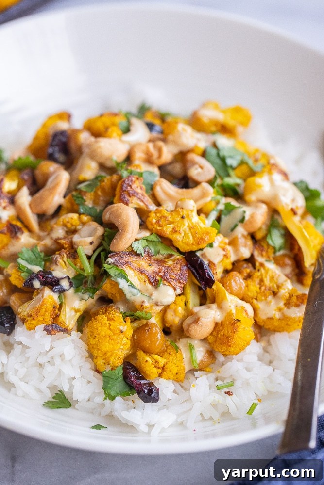 Close-up detailed view of curry roasted cauliflower florets with chickpeas, showcasing their golden color and seasoning.