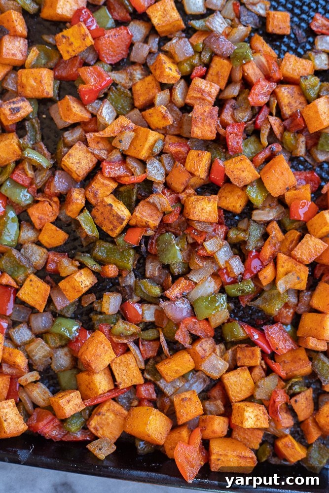 Golden Sweet Potato Skillet 4 A sheet pan filled with perfectly roasted sweet potato hash, golden brown and caramelized, showcasing the delicious result of the roasting process.