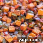 Roasted sweet potato hash on a sheet pan with caramelized veggies