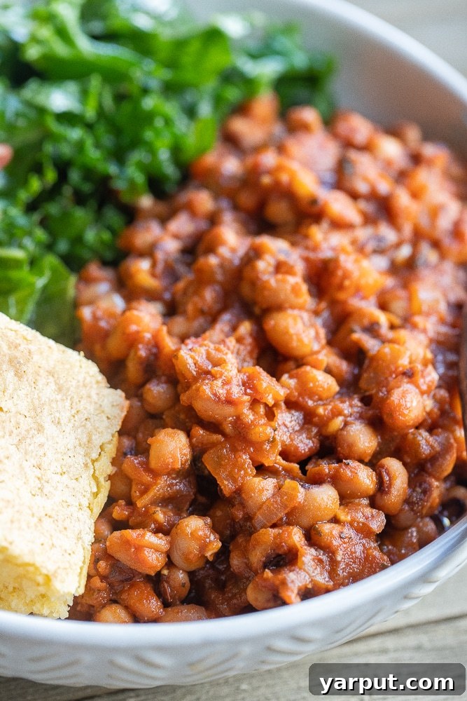 Smoky BBQ Black-Eyed Peas 4 Close up of two bowls of BBQ Black Eyed Peas, served with cornbread and greens.