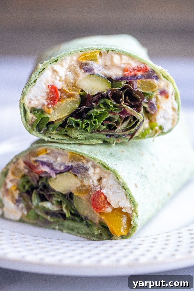 Zesty Roasted Veggie Hummus Wraps with Crumbled Feta 6 Multiple roasted veggie hummus wraps, perfectly sliced in half and stacked, showcasing the vibrant and healthy layers.