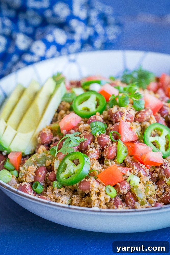 Simplify Your Week 5 Meals 4 A vibrant bowl of red beans served alongside fluffy cauliflower rice, garnished with fresh cilantro and a lime wedge.