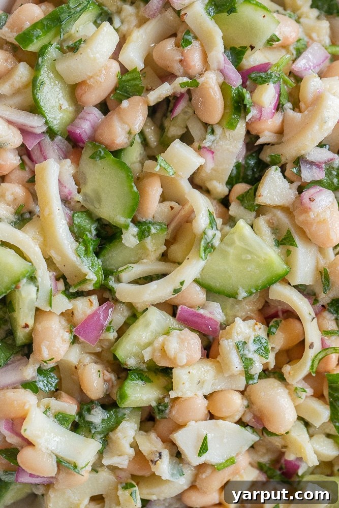 close up of a generous serving of lemony hearts of palm and white bean salad in a bowl