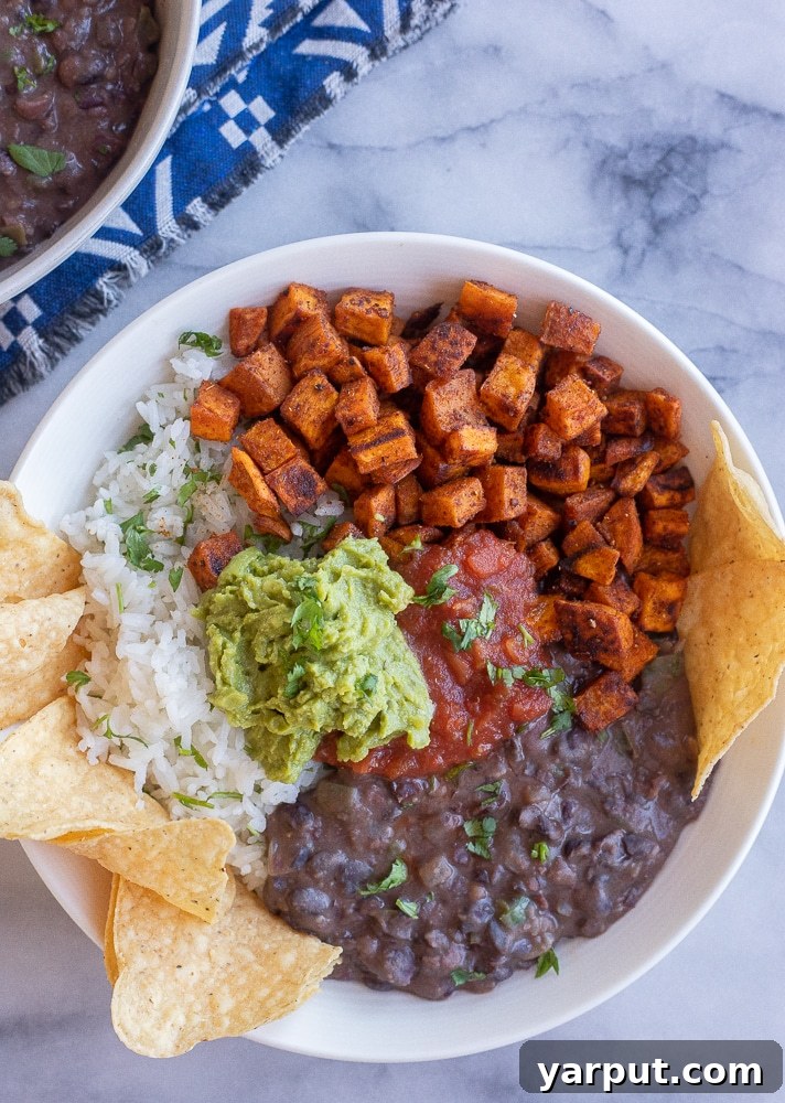Affordable Plant-Based Feasts Week 13 6 A colorful Roasted Sweet Potato Burrito Bowl, filled with roasted sweet potatoes, black beans, corn, avocado, and a sprinkle of fresh cilantro.