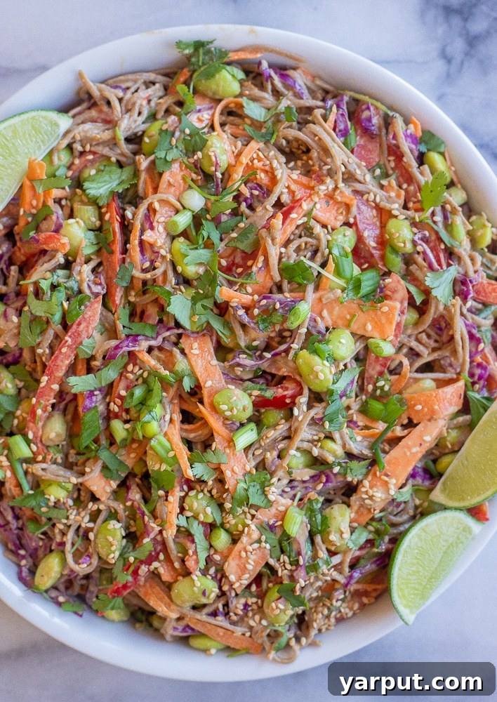 Peanut Soba Noodle Power Bowl 2 Peanut Soba Noodle Salad with vibrant vegetables in a large bowl, garnished with fresh limes