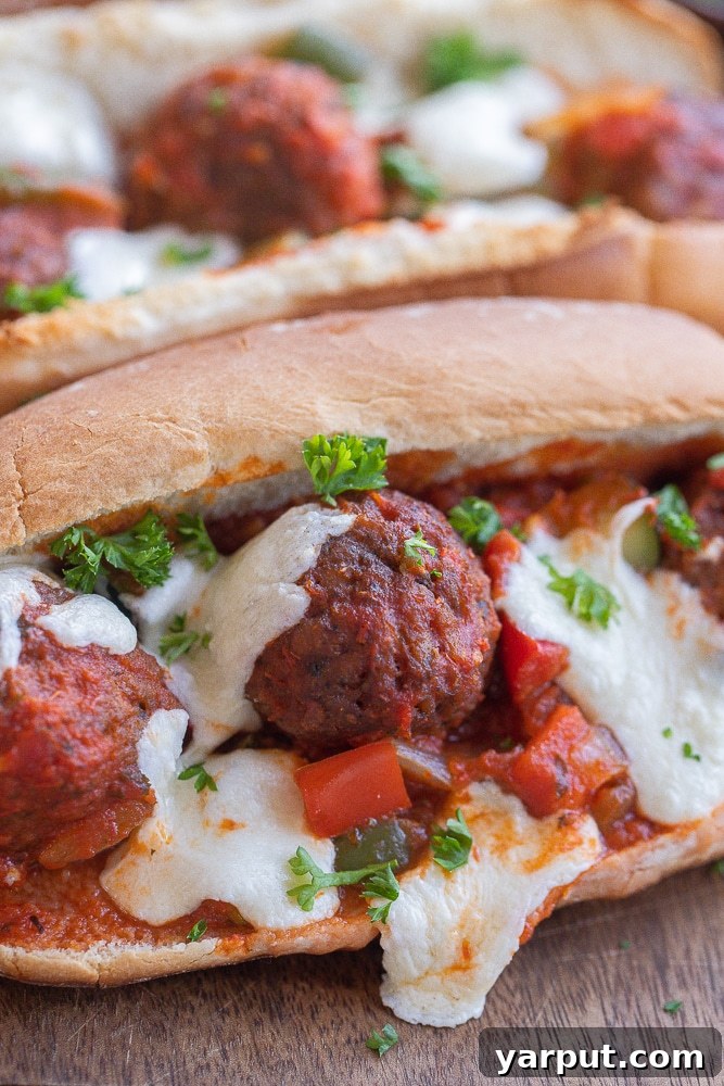 Hearty Plant-Based Meatball Subs 6 Close-up of a mouth-watering plant-based meatball sub sandwich with melted cheese and fresh herbs.