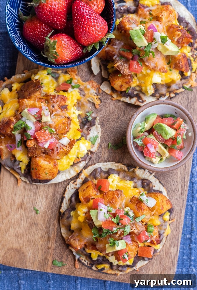 breakfast potato tacos on a cutting board with avocado salsa and strawberries