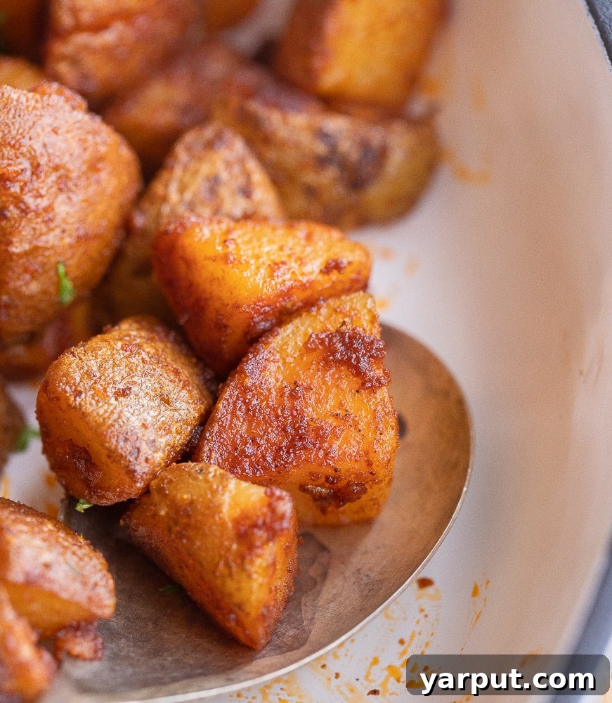 close up of quick and easy home fries on a spoon, ready to eat
