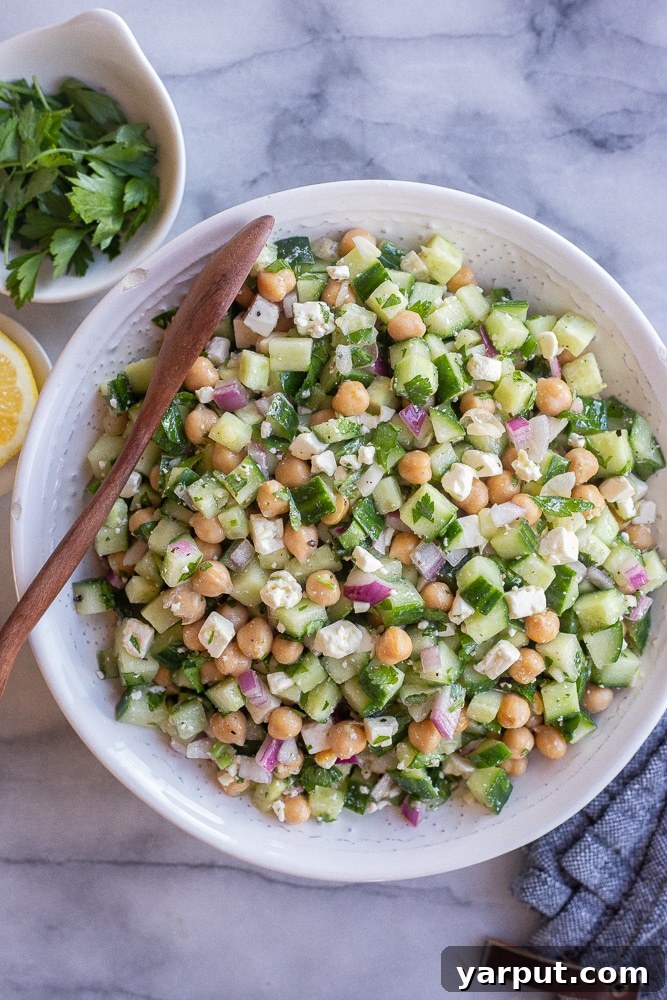 Fresh Herby Cucumber, Feta, and Chickpea Salad 5 A vibrant bowl of Herby Cucumber Salad with Feta and Chickpeas, garnished with fresh mint leaves, ready to be served and enjoyed.