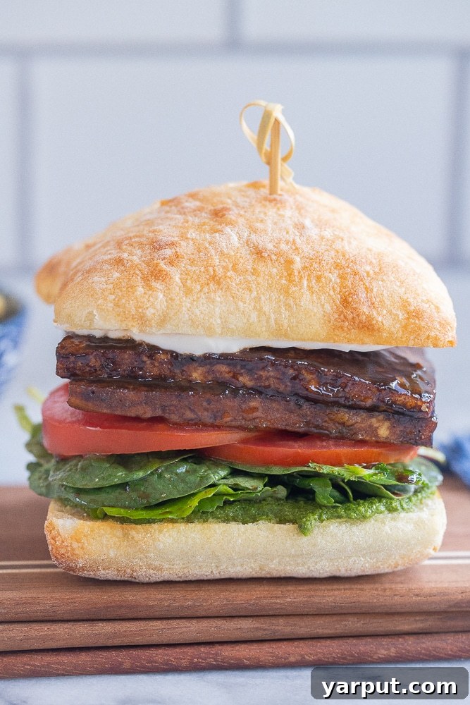 Affordable Vegetarian Eats: Week 17 Menu 3 Balsamic Tofu Sandwiches with Pesto on a wooden board with a side salad
