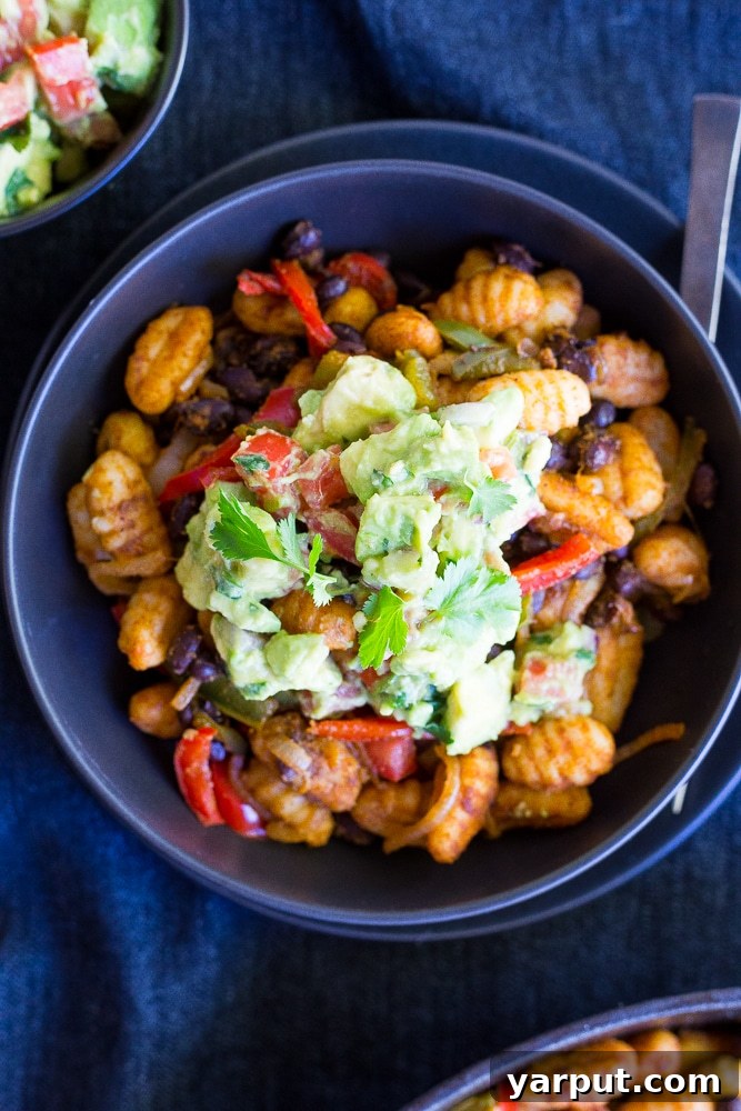 Affordable Vegetarian Eats: Week 17 Menu 5 Fajita Gnocchi Skillet with avocado salsa in a cast iron pan