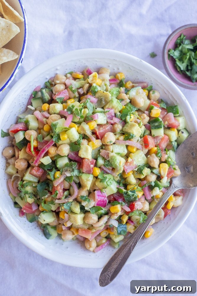 Tangy Avocado and Cucumber Salad with Pickled Onions 5 A beautiful serving bowl of Pickled Onion and Avocado Salad, presented alongside a bowl of crispy corn chips, inviting guests to enjoy it as a side or a dip.