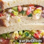 A Greek Salad Sandwich with Hummus, photographed from above.