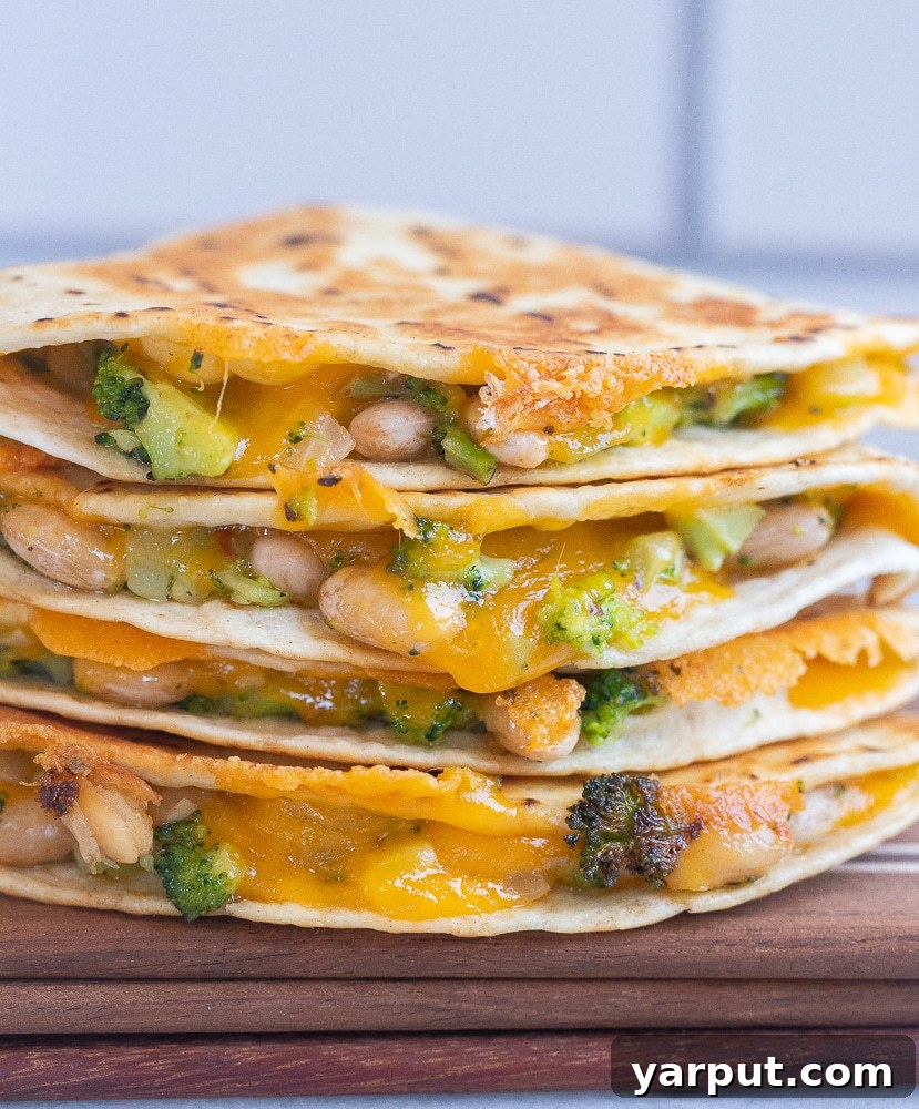 Creamy Broccoli, Cheddar, and White Bean Quesadillas 2 Stacked Broccoli Cheddar and White Bean Quesadillas ready to enjoy, showcasing golden tortillas and vibrant filling