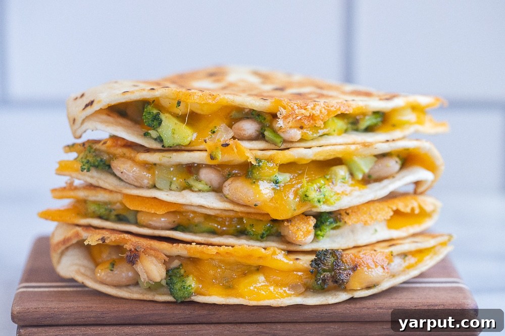 Creamy Broccoli, Cheddar, and White Bean Quesadillas 6 Close-up of freshly cooked Broccoli Cheddar and White Bean Quesadillas on a wooden cutting board, ready to be served