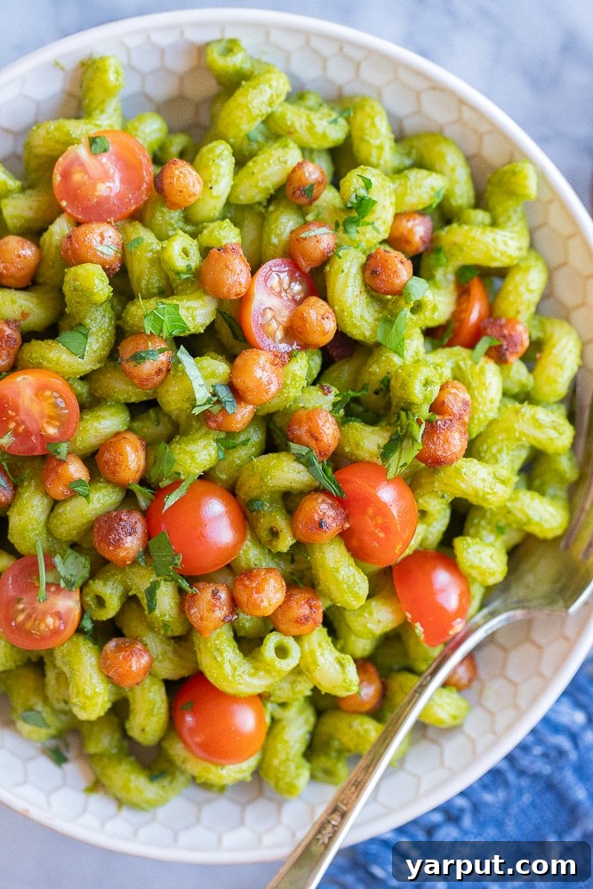 Vibrant Lemon Jalapeno Pasta with Crispy Chickpea Crunch 6 A close-up overhead shot of a bowl of herby lemon jalapeno pasta with crispy chickpeas and cherry tomatoes, ready to be enjoyed.