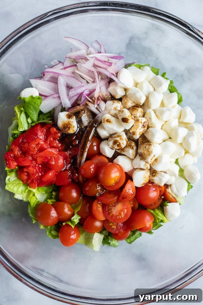 Mediterranean Caprese Sandwich 3 Fresh Caprese salad ingredients in a bowl, with balsamic glaze drizzled over, ready for sandwich assembly