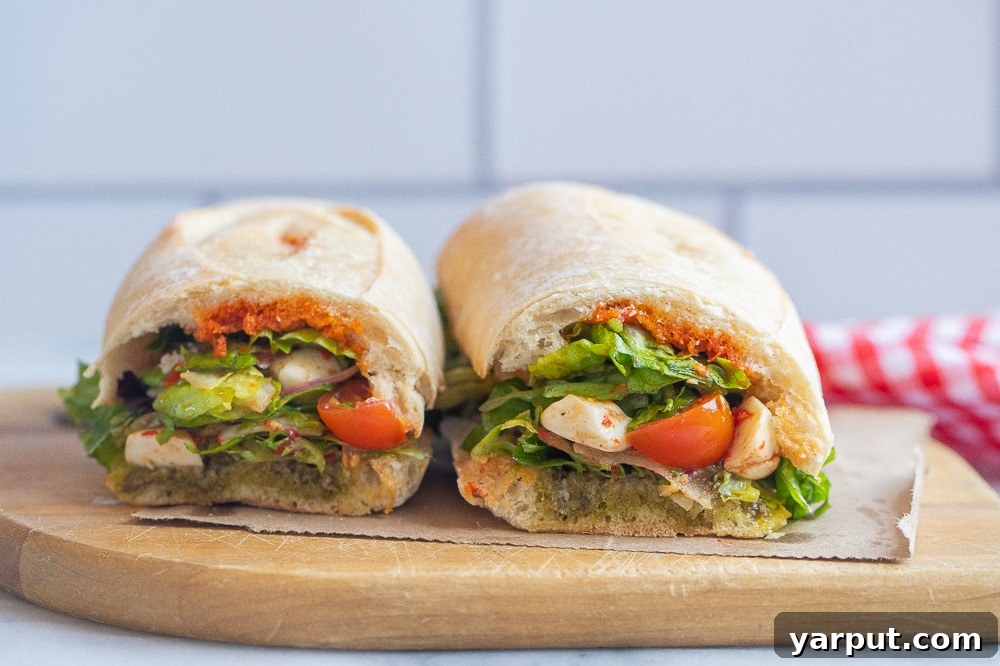 Mediterranean Caprese Sandwich 6 Two Caprese salad sandwiches placed side-by-side on a rustic cutting board, ready to be enjoyed