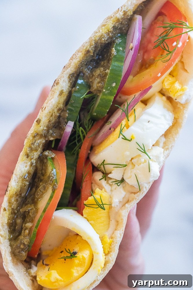 Veggie Morning Pockets 2 a hand holding a vegetarian breakfast pita